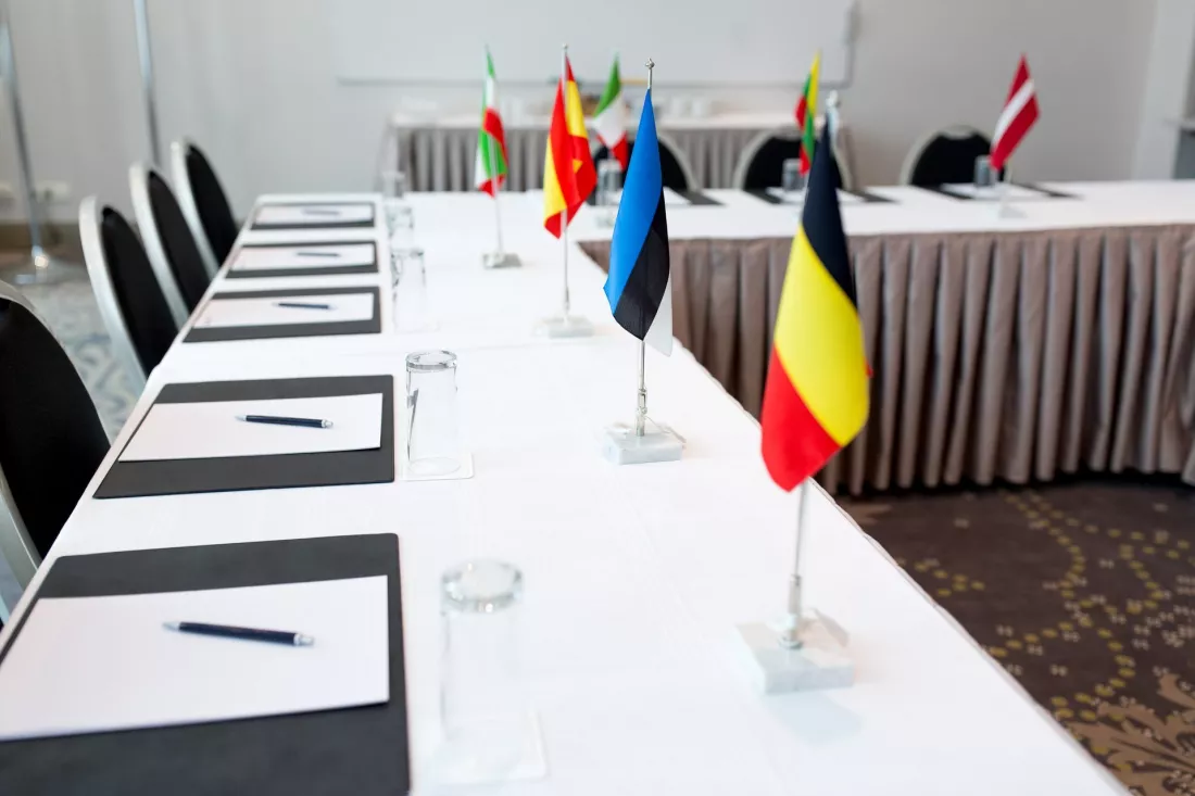 stol-konferencyjny-z-flagami-panstw-ug-tekst