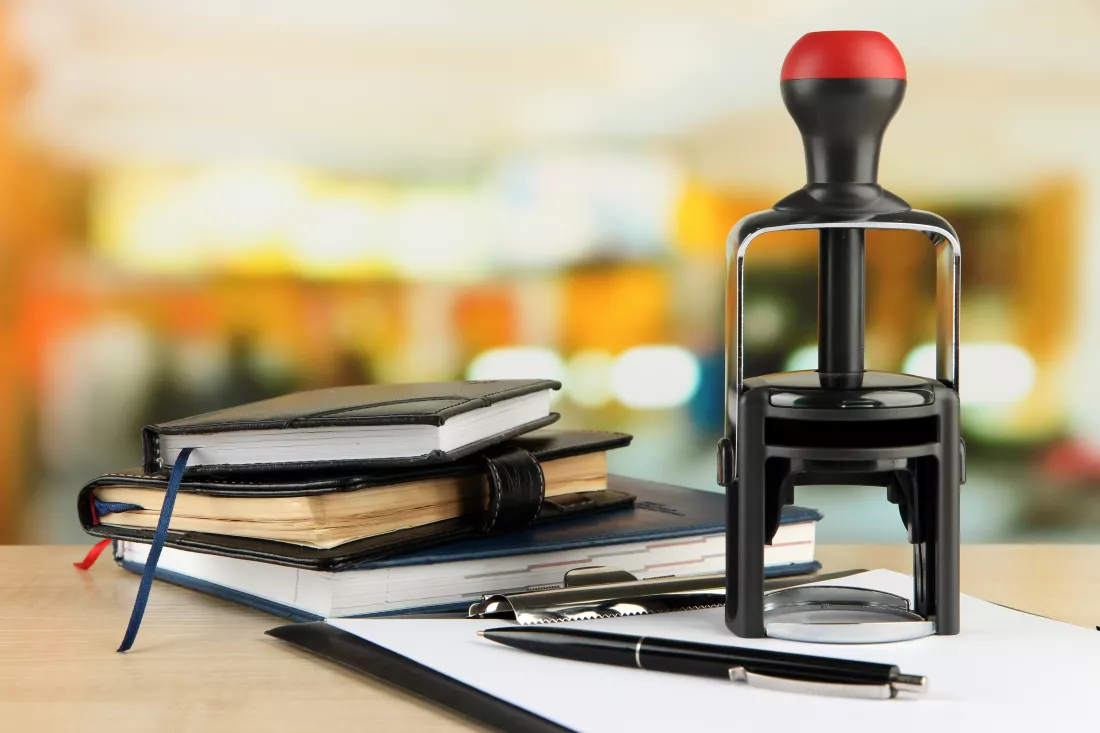 stamp-with-notepads-clipboard-table-bright-background