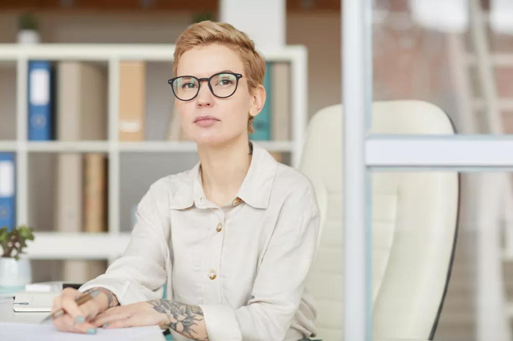 portrait-confident-tattoed-businesswoman-while-sitting-desk-office-copy-space
