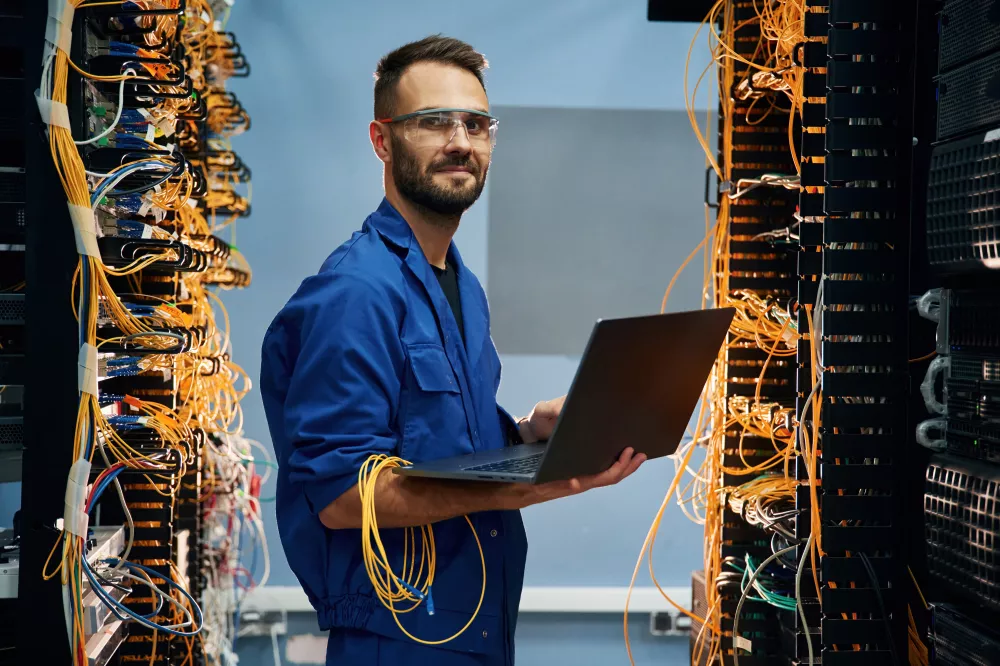 with-laptop-hands-young-man-is-working-with-internet-equipment-wires-server-room