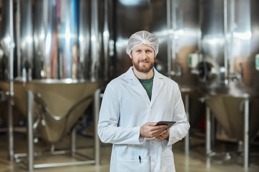 male-worker-standing-food-factory-workshop-holding-digital-tablet