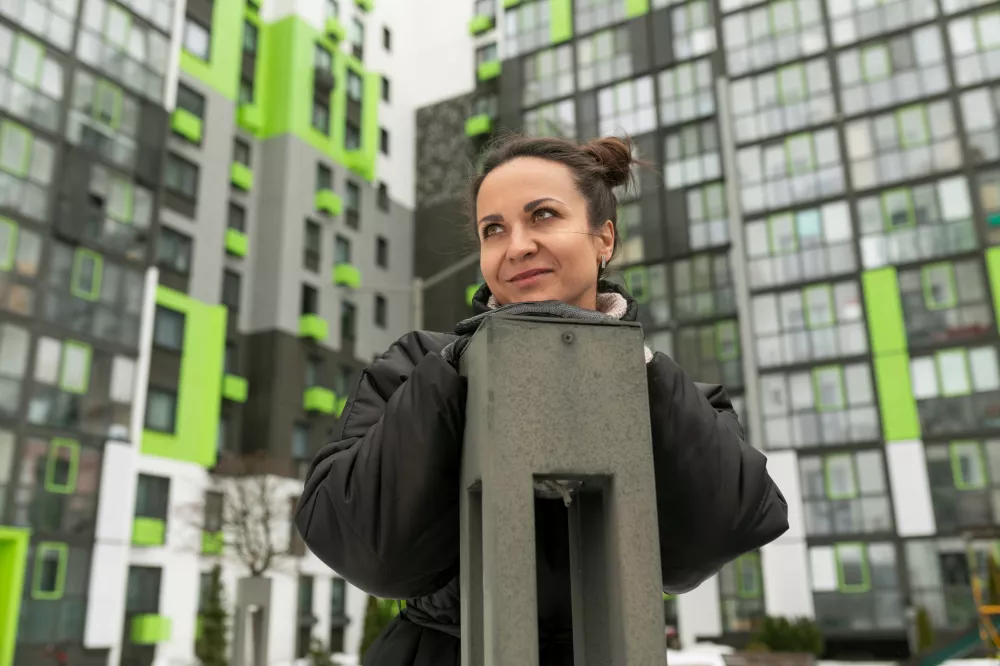 lifestyle-concept-young-woman-walking-courtyard-highrise-building-winter