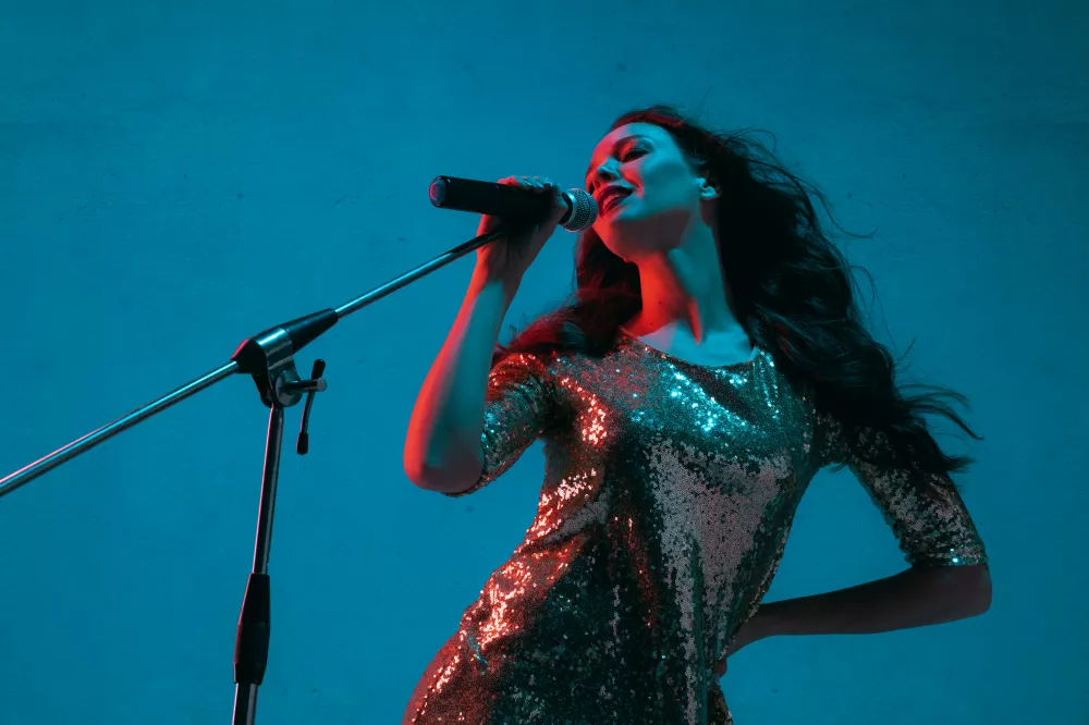 caucasian-female-singer-portrait-isolated-blue-studio-background-neon-light
