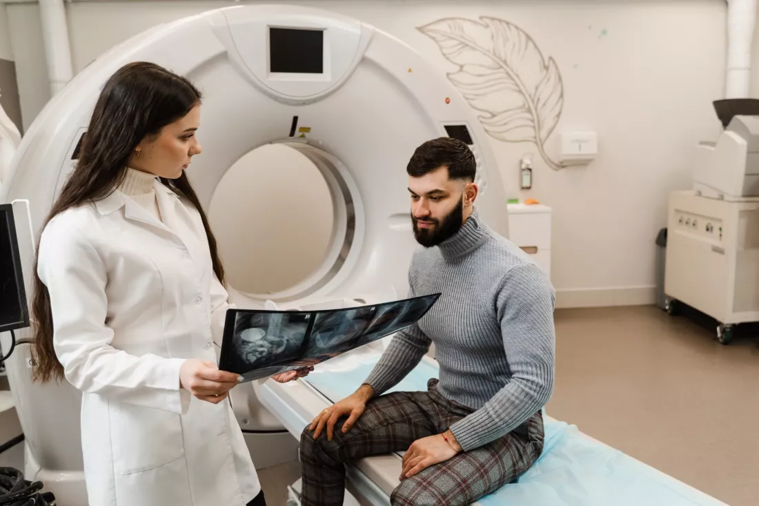 Elektroradiolog omawia z pacjentem badanie w pracowni tomografii komputerowej