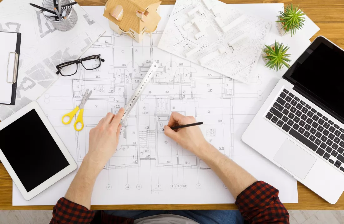 Architekt nad rysunkami projektowymi w pracowni