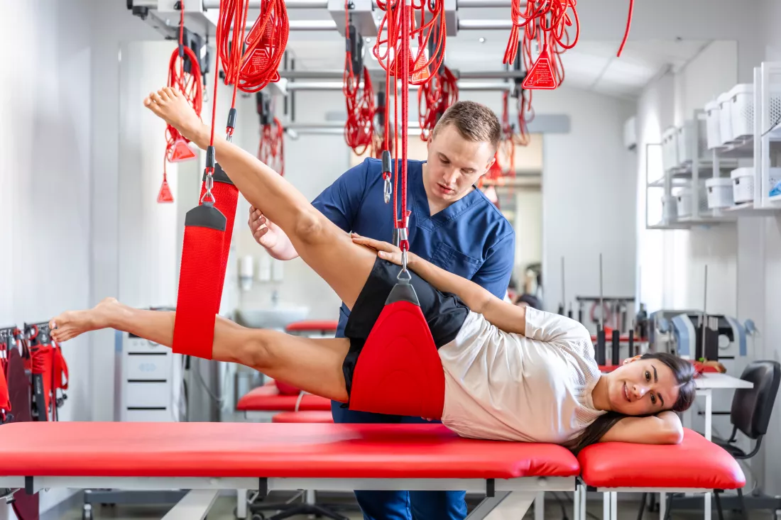 female-patient-hanging-suspensions-rehabilitation-center
